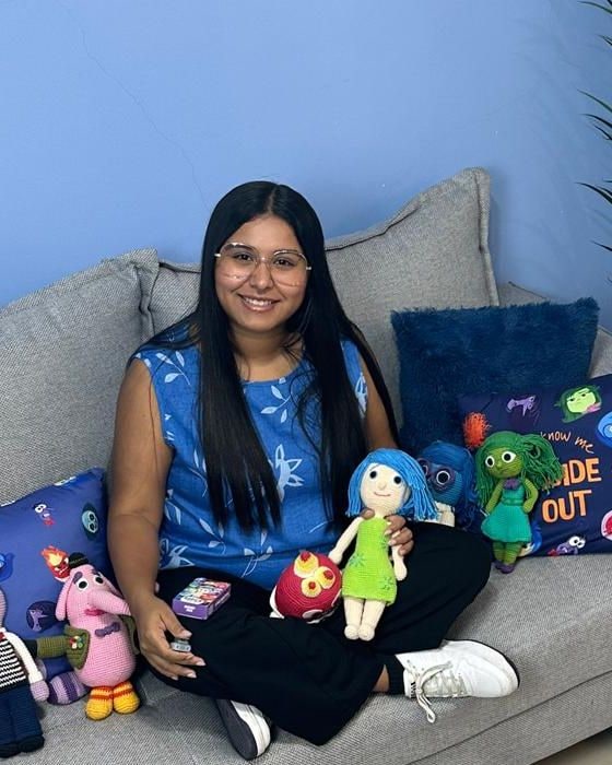 Caroli Gil, psicóloga, sentada en el sillón de su consultorio con muñecos tejidos de las emociones